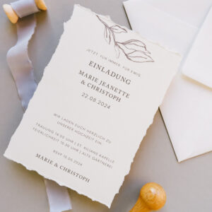 Aufsicht Einladungskarte mit gerissenen Papierkanten und dekorativen Elementen